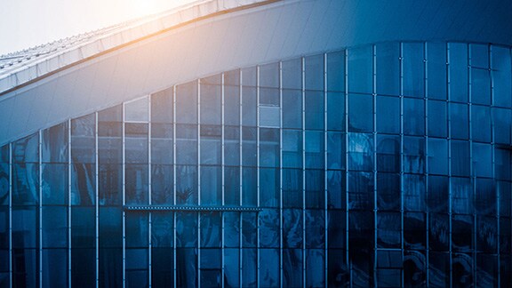 Close up of the sunlit edge of a commercial building with glass windows
