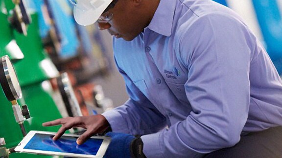 A male maintenance engineer scrolling on a tablet