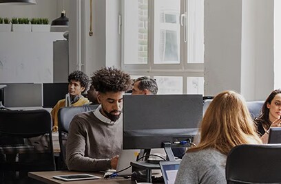 Business people using computers during meeting.